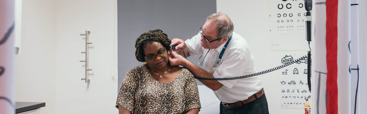 Doctor checking up on woman's ear